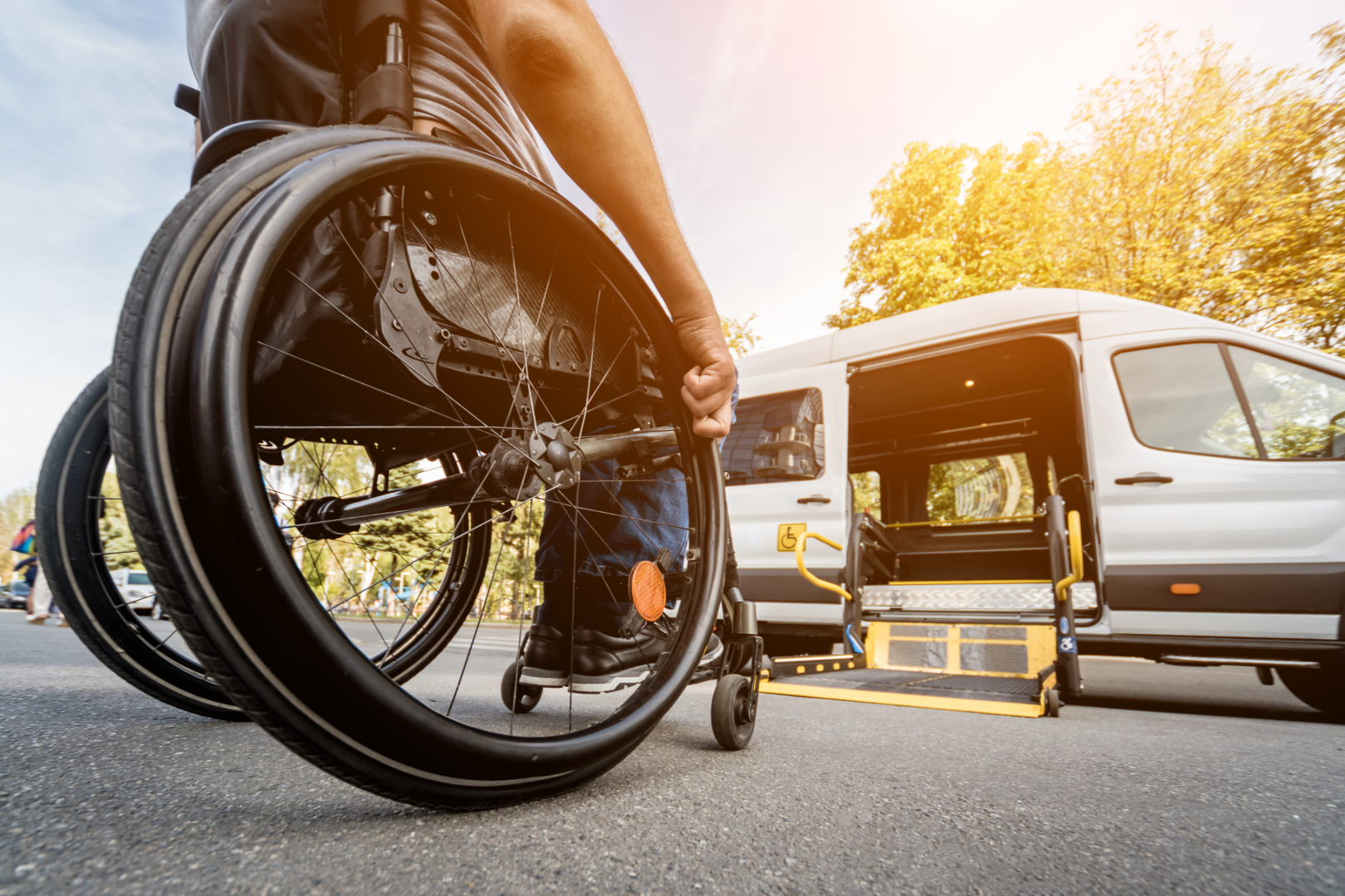 client on wheelchair in front of lift of van