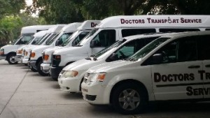 A row of white vans parked in a parking lot.